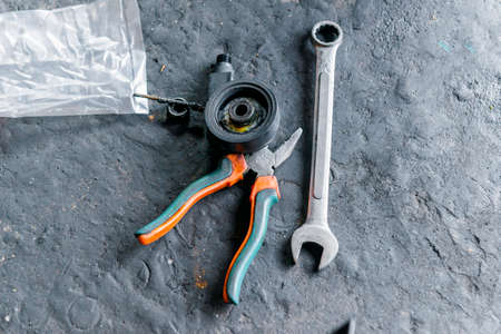 Wrench and pliers with motorcycle spare parts on the workshop