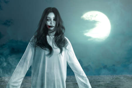 Scary ghost woman standing with night scene background. Halloween conceptの写真素材