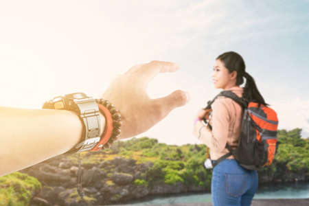 Asian woman with a backpack with a lake view and blue sky background. World Tourism Day