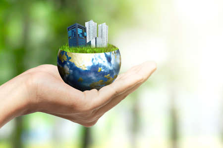 Human hand holding earth with buildings and apartments. World Habitat Dayの写真素材