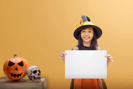 Asian witch little girl holding an empty board with a colored background. Empty board for copy spaceの写真素材