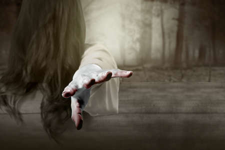 Scary ghost woman standing with haunted forest background. Halloween concept