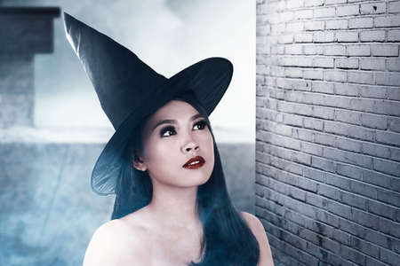 Asian witch woman with a hat standing in the abandoned building