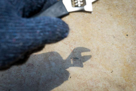 Hand with glove holding wrench handle at outdoorの写真素材