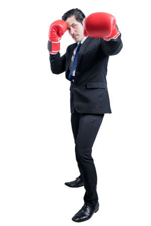 Asian businessman with red boxing gloves fighting isolated over white backgroundの写真素材