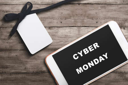 Cyber Monday text on the mobile phone screen with a wooden background. Cyber Monday conceptの写真素材