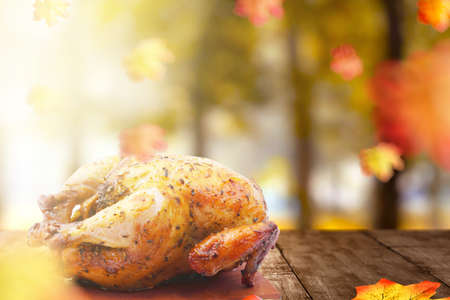 Roasted turkey on wooden table with autumn leaves. Happy Thanksgivingの写真素材