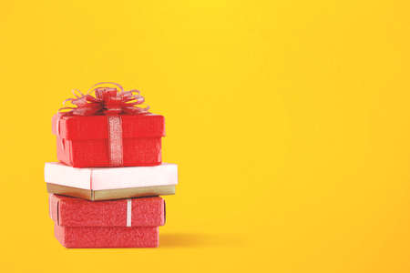 Stack of colorful gift box with red ribbon on a colored background. Cyber Monday concept