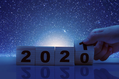 Hand changes the wooden cube from 2020 to 2021. Happy New Year 2021