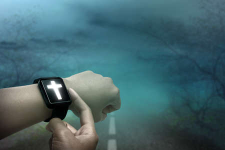 Digital wristwatch with Christian cross on human hand with the night scene backgroundの写真素材