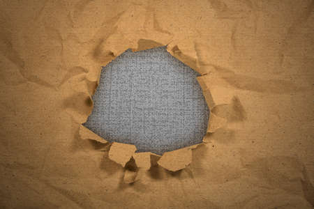 Paper with a hole torn in the middle with black backgroundの写真素材