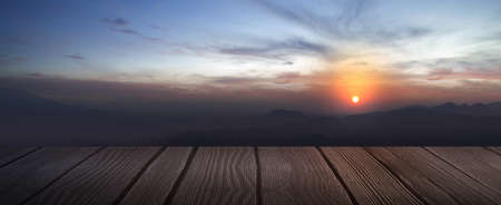 Wooden floor with landscape view with hills and sunrise sky backgroundの写真素材