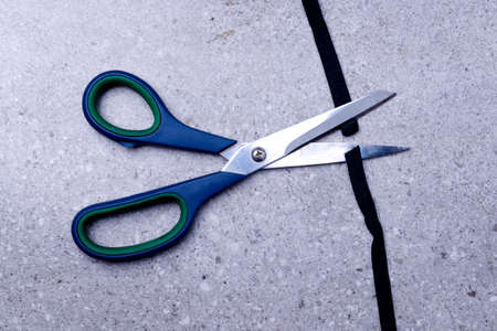 Scissor cutting the black ribbon on the tableの写真素材