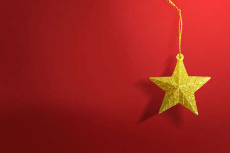 Golden Christmas ornament hanging with a colored background. Merry Christmasの写真素材
