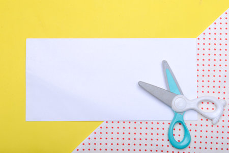 Scissor and empty white paper with a colored background. Empty white paper for copy space