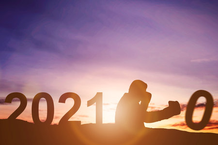 Silhouette of businessman changing 2020 to 2021. Happy New Year 2021