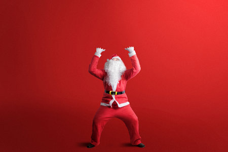 Asian man in Santa's costume is afraid of something with a colored background. Merry Christmasの写真素材