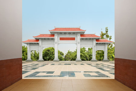 Chinese pavilion gate with red roof with garden view and a blue sky background