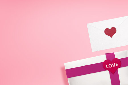 White gift box with a red ribbon and heart shape with LOVE text and envelope with a colored background. Valentines dayの写真素材
