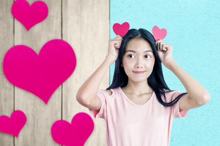Asian woman holding the red heart with a blue background. Valentines dayの写真素材