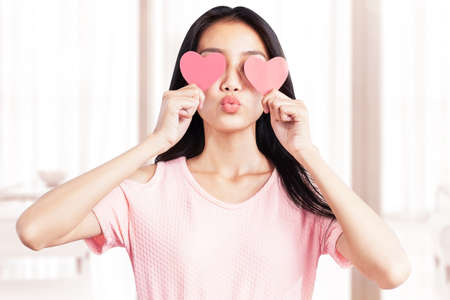 Asian woman holding the red heart at home. Valentines dayの写真素材