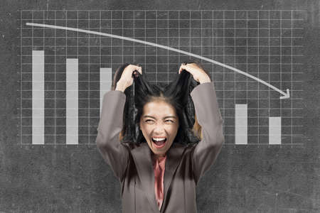 Asian businesswoman feeling depressed with global economic impact because coronavirus pandemicの写真素材