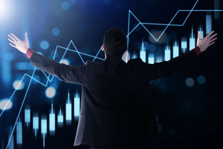 Rear view of Asian businessman looking a virtual bar chart with digital background