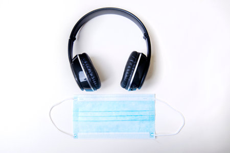 Black headphone and face mask isolated over white background