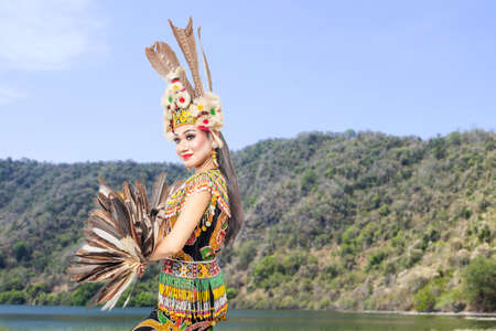 Asian woman dancing East Kalimantan traditional dance (Giring-Giring dance) at outdoorの写真素材