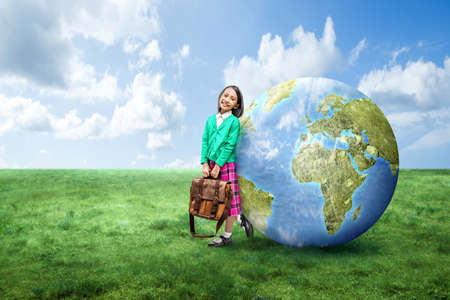 Asian little girl with a glasses standing with the earth on the field. World Children Dayの写真素材