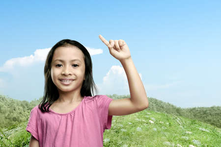Asian little girl raised hands with a blue sky background. World Children Dayの写真素材