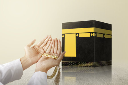 Muslim man praying with prayer beads on his hands in front of the Kaaba with bright backgroundの写真素材