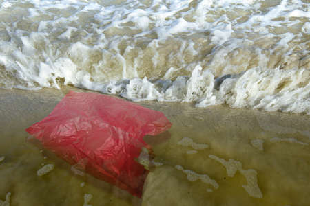 Plastic bag on the sandy beach. Plastic pollutionの写真素材