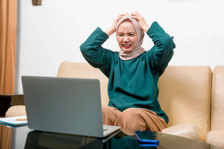 Asian Muslim businesswoman using a laptop working from home. Prevent flu disease Coronavirus