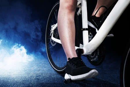 Side view of a woman riding a bicycle with bright background