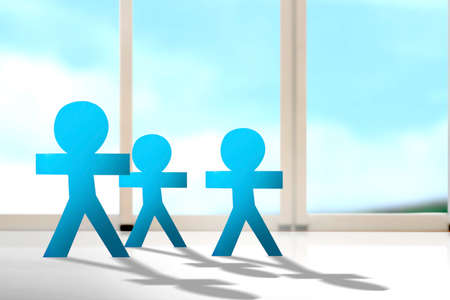 Blue people paper standing with the window background. World Population Day concept