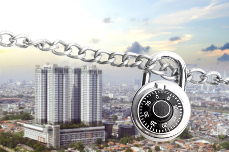 Chain of metal steel with padlock and cityscape with a blue sky background