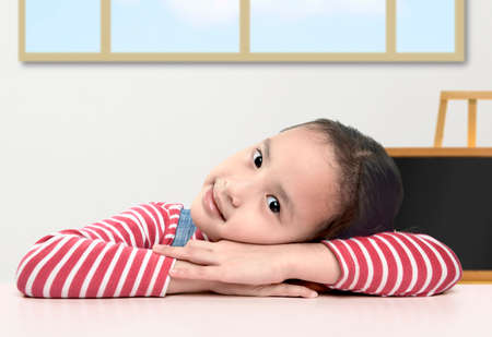 Asian little girl lying on the table. Back to School concept