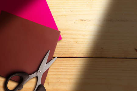 Colored paper with scissors on wooden backgroundの写真素材