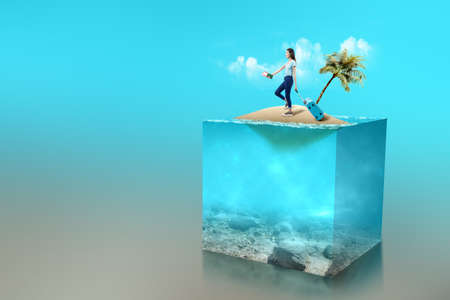 Asian woman with a suitcase holding ticket and passport on a little island with an underwater view of blue water on the ocean. Environment conceptの写真素材