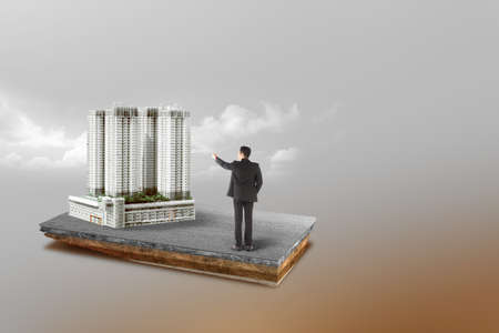 Underground soil layer of cross-section earth Asian businessman pointing modern building on the streetの写真素材