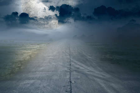 Asphalt road with green grass and moonlight backgroundの写真素材
