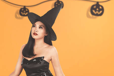 Asian witch woman with a hat standing with a colored background
