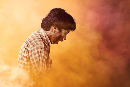 Scary zombie with blood and wound on his body standing with dramatic backgroundの写真素材