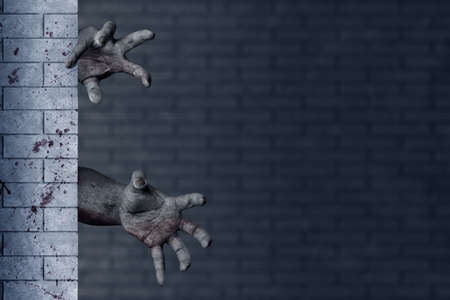 Zombie hand with blood and wound behind the brick wall in an abandoned buildingの写真素材
