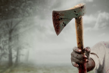 Zombie hands with wound holding an ax in a haunted forestの写真素材