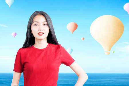 Asian woman with colorful air balloon flying with blue sky backgroundの写真素材