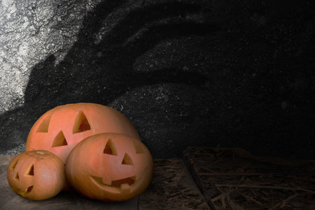 Jack-o-Lantern on a wooden table with a grunge wall background