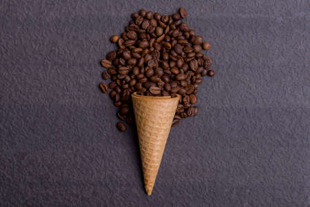 Ice cream cone with coffee beans on black backgroundの写真素材