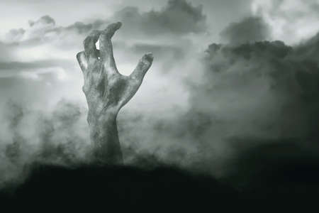 Zombie hand with blood and wound raised from the groundの写真素材